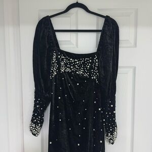 Black velvet dress covered with gems and pearls.